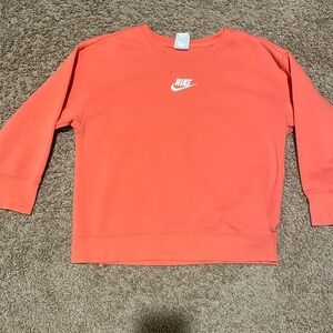 A kids Nike pink/peach color size small it’s a cute and comfortable crew neck.